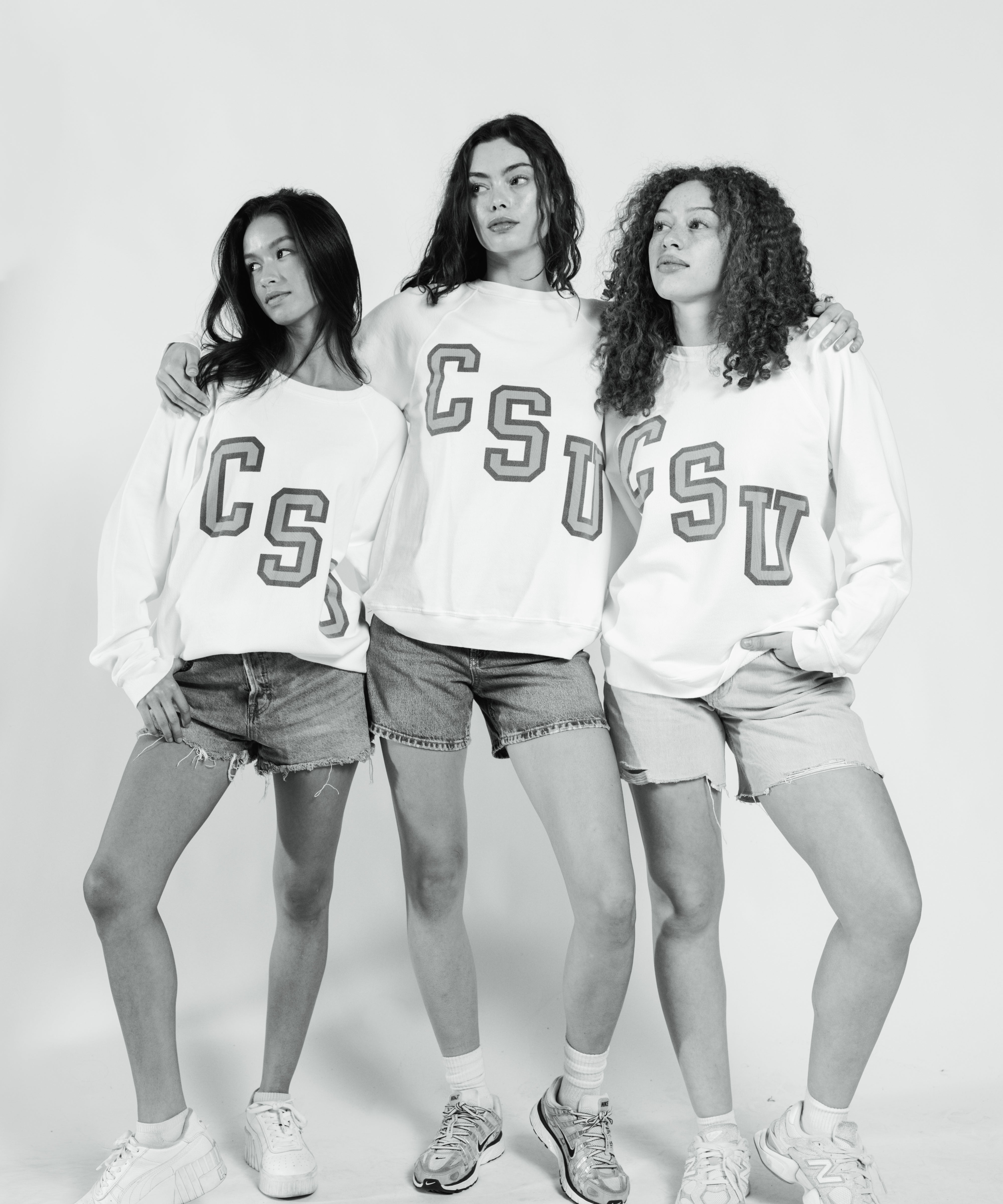 Three women wearing matching sweatshirts with 'CSU' on a white background