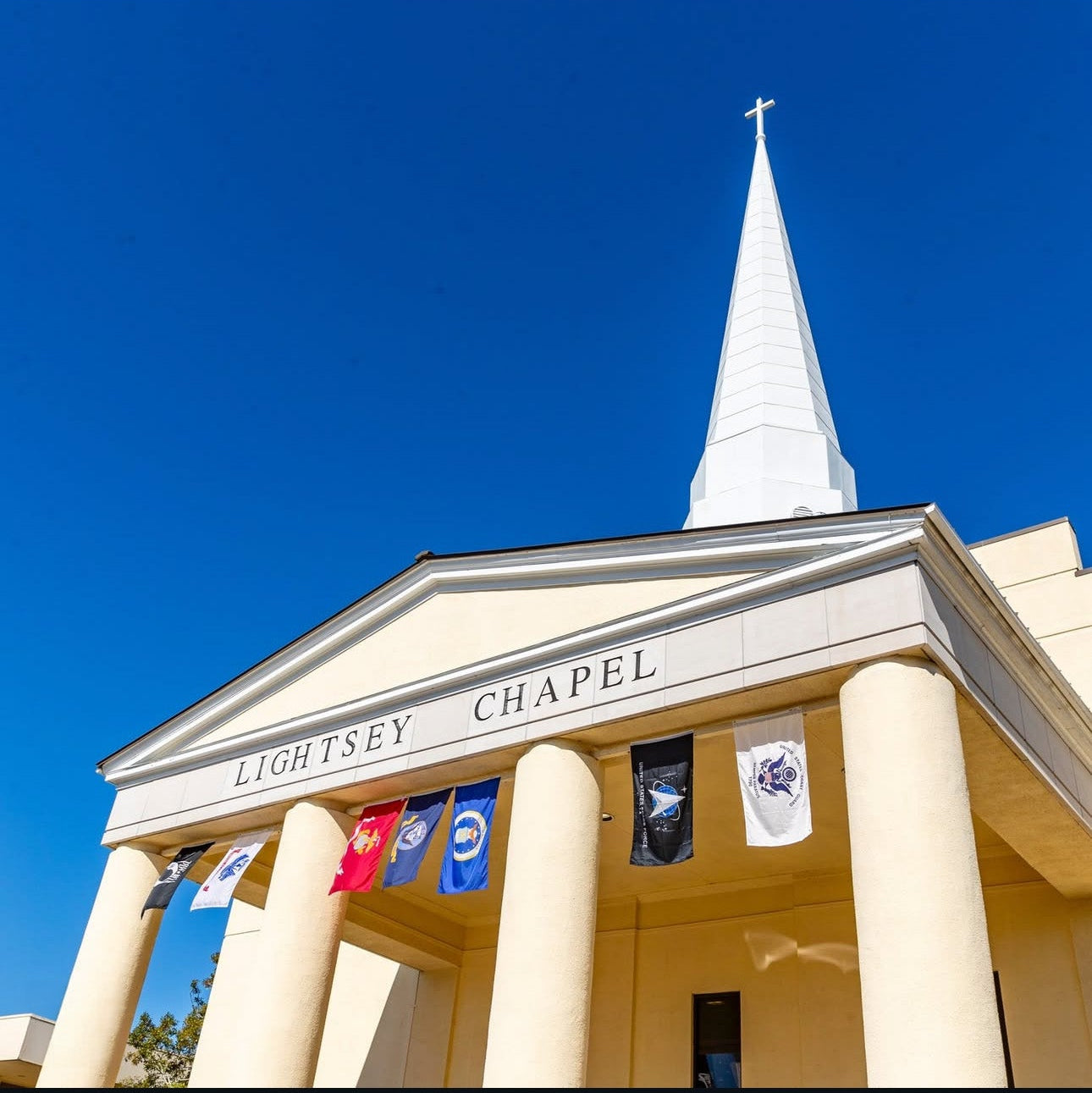 Lightsey Chapel with a clear blue sky and flags on a sunny day